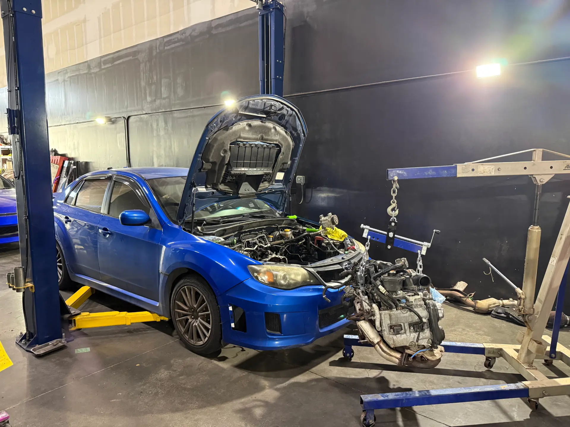 Subaru WRX with the engine pulled on a hoist