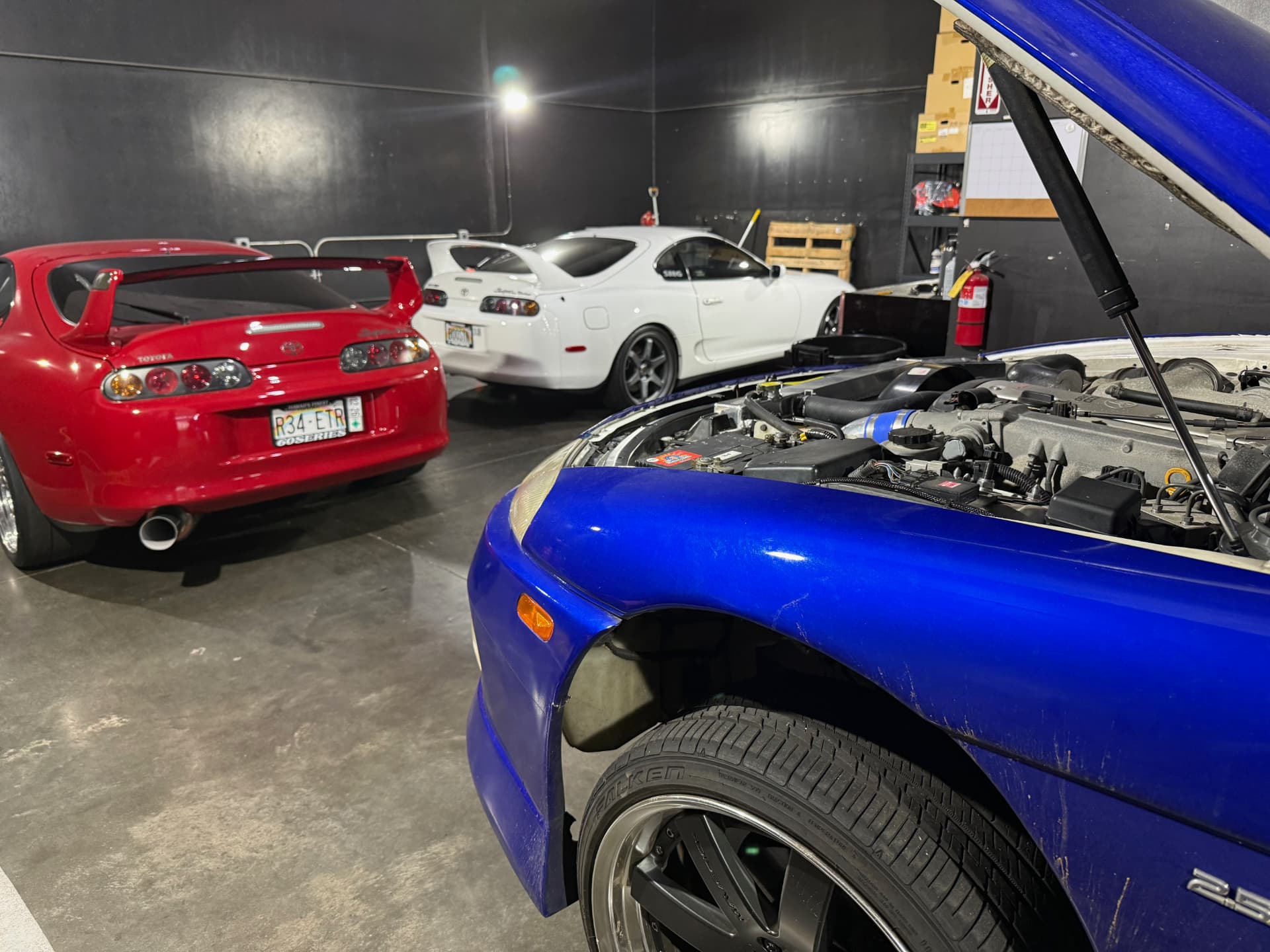 Two Toyota Supras and a Nissan parked inside the shop