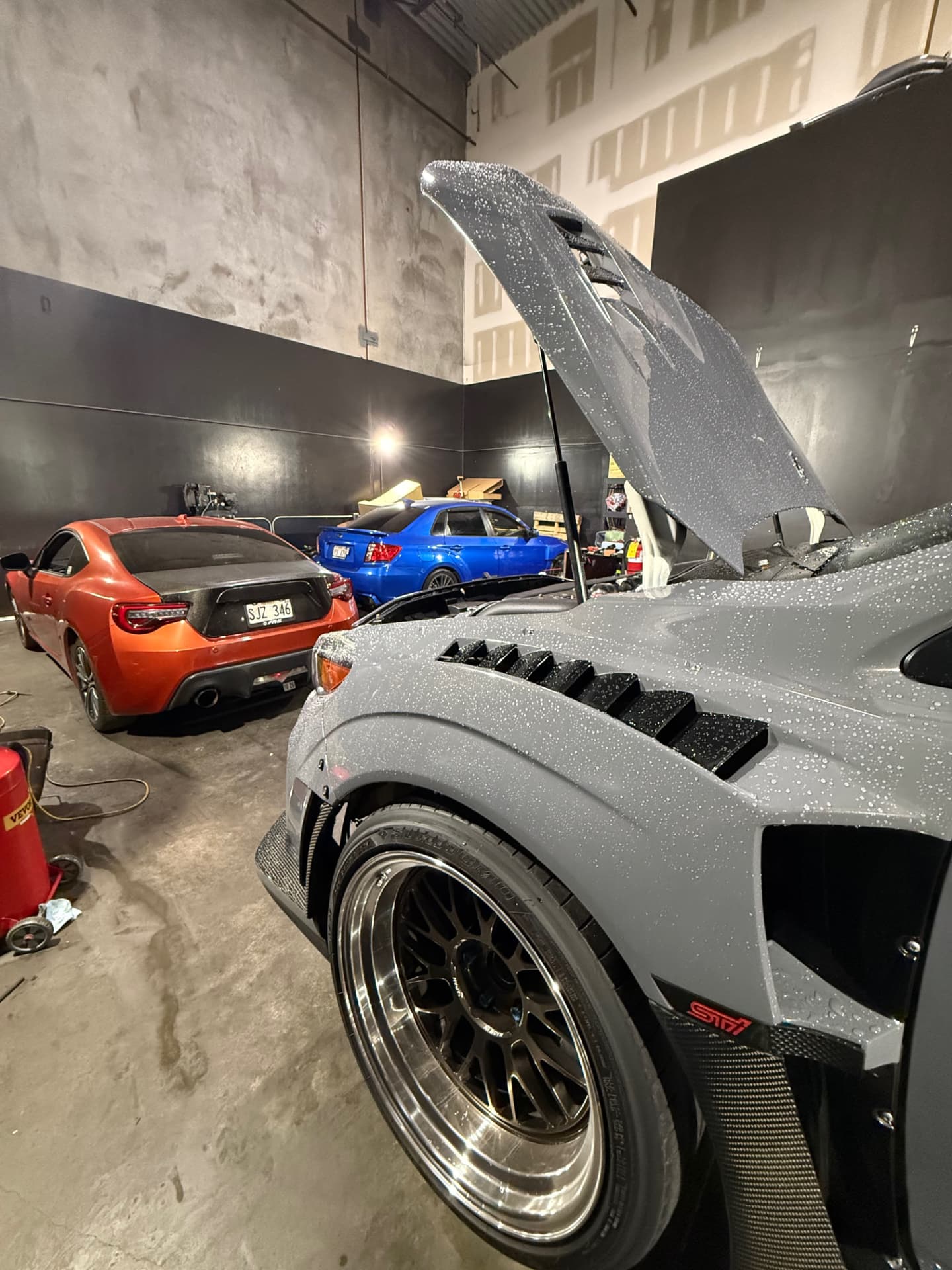 Widebody Subaru STI under service next to other builds